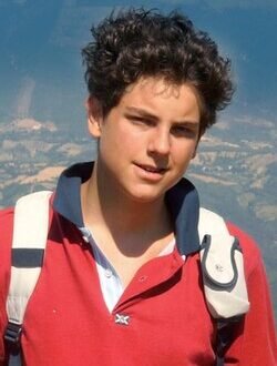 Image of St Carlo Acutis with Italian scenery behind him.