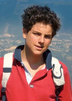 Image of St Carlo Acutis with Italian scenery behind him.