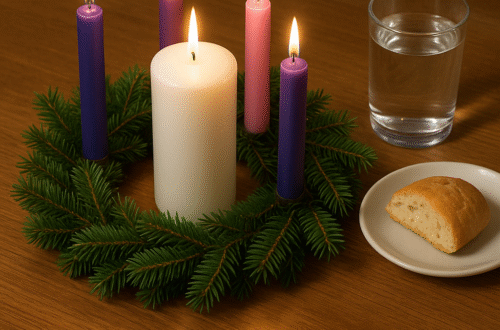 Advent wreath with a piece of bread and glass of water next to it.